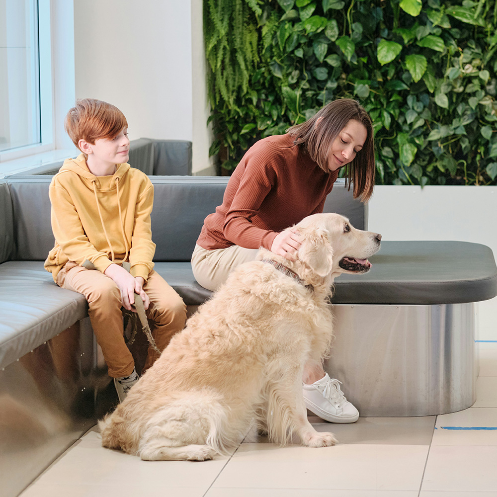 mother and son with their dog in the veterinary waiting room